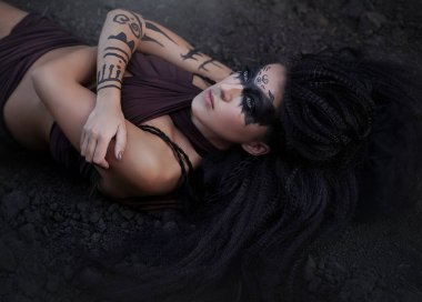 Vahşi bir Amazon kızının portresi. Uzun siyah saçlı ve ritüel makyajlı şaman kız..