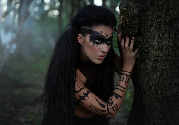 Portret close up of beautiful tribal shaman woman in a foggy forest.Amazon girl near the tree. Soft focus — Stock Photo, Image