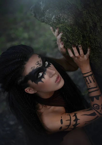 Ett närporträtt av en vild Amazonflicka. Shaman flicka med långt svart hår och rituell makeup. — Stockfoto