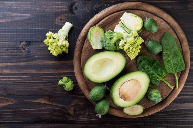 Yeşil sebze ve meyve ahşap rustik arka planda, düz yatıyordu Mix