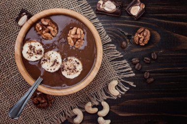 Düz ev yapımı çikolata muz smoothie ahşap arka plan üzerine bir kase üzerinde yatıyordu