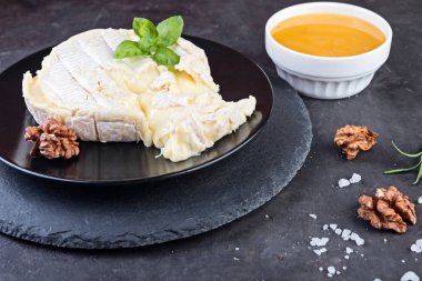 Camembert peyniri ceviz ve fesleğen karanlık taş tahta üzerinde