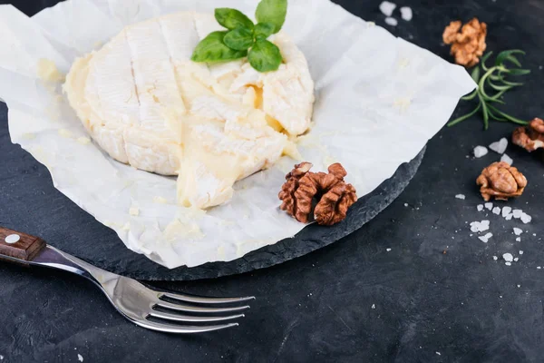 Camembert Mit Walnüssen Und Basilikum Auf Dunklem Steinbrett — Stockfoto