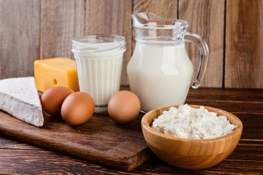 Süt ürünleri üzerinde rustik ahşap bir masa. Süt, peynir ve yumurta.