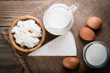 Lezzetli süt ürünleri üzerinde rustik ahşap masa, üstten görünüm.