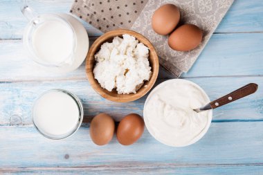 Lezzetli süt ürünleri üzerinde rustik ahşap masa, üstten görünüm.