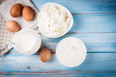 Lezzetli süt ürünleri üzerinde rustik ahşap masa, üstten görünüm.