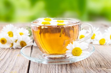 fincan Papatya çayı ve ahşap arka plan üzerinde papatya çiçekler