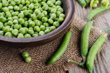 Rustik ahşap masa üzerinde ahşap kase bezelye