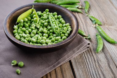 Rustik ahşap masa üzerinde ahşap kase bezelye