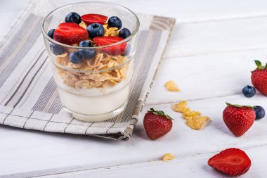 Müsli ve çilek Beyaz ahşap arka planda, seçici odak ile taze yoğurt