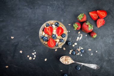 Sağlıklı Kahvaltı, taze meyveler ve karanlık bir arka plan üzerine müsli ile Doğal yoğurt
