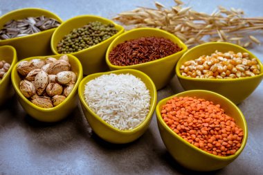 Farklı tahıl, tohum, fasulye gri beton masada seramik kase