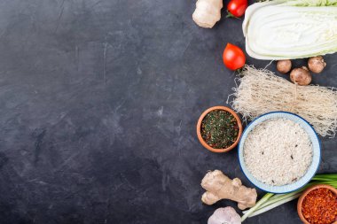 Çiğ pirinç noodle ile baharat koyu arka plan üzerinde. Üstten görünüm. Uzay kopyalayın. Sağlıklı vejetaryen gıda kavramı.