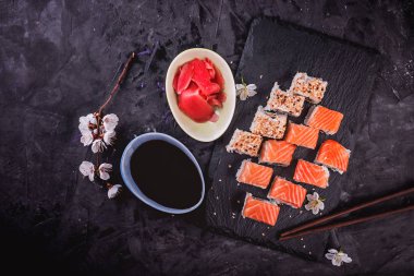 Philadelphia rulo ile somon, avokado, siyah arka plan üzerine yılan balığı. Üstten görünüm