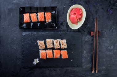 Philadelphia rulo ile somon, avokado, siyah arka plan üzerine yılan balığı. Üstten görünüm