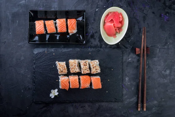 Philadelphia rulo ile somon, avokado, siyah arka plan üzerine yılan balığı. Üstten görünüm