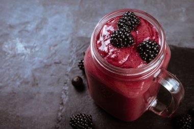 Nane ve koyu arka plan üzerinde kavanoza taze çilek ile BlackBerry doğal güler yüzlü 