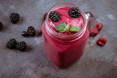 Nane ve koyu arka plan üzerinde kavanoza taze çilek ile BlackBerry doğal güler yüzlü 