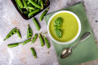 Yeşil bezelye çorbası seramik kase gri bir arka planda üstten görünüm