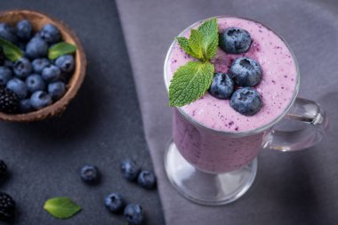  güler yüzlü veya taze yaban mersini ve karanlık bir arka plan üzerine nane ile sallamak