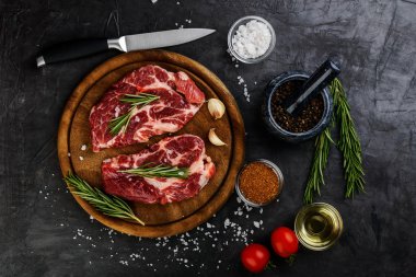 Biberiye ve siyah arka plan, üstten görünüm ahşap bir gemide içinde baharatlar ile çiğ et