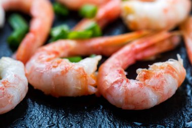 Pişmiş karides, karides çeşnilikler ile taş koyu arka plan üzerinde yakın çekim 