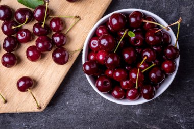 Gri taşlı arka planda taze kirazlar.