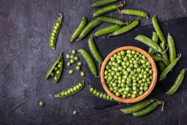 Siyah arka planda kabuklu bezelyeler.