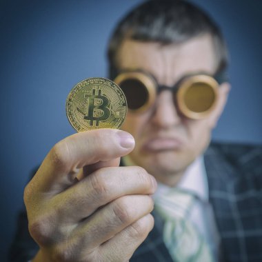 bitcoin-bitcoin madeni para güvensizlik ile görünüyor bir işadamı ile gözlük, elinde