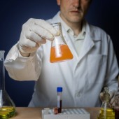 Chemical formulation for medicine, laboratory research. The laboratory assistant holds a flask in his hand.