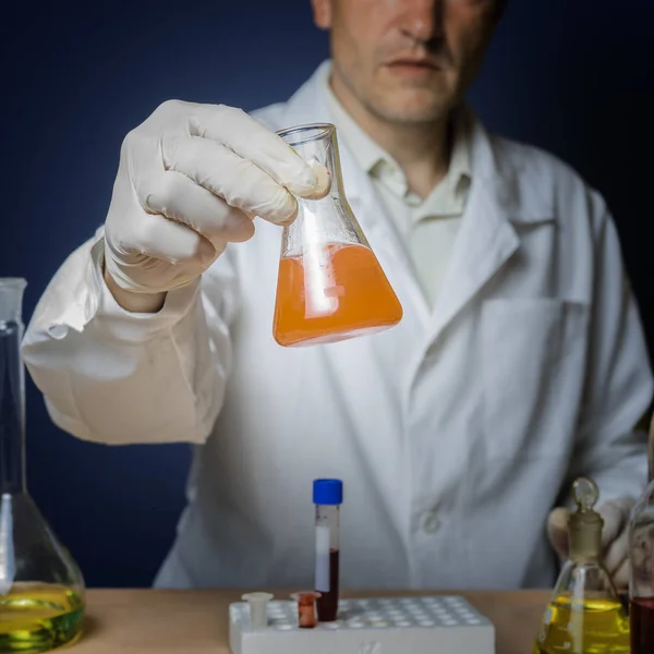 Kemisk formulering för medicin, laboratorieforskning. Laboratorie assistenten håller en kolv i handen. — Stockfoto