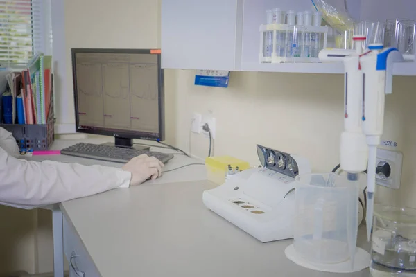 Erkek bilim adamı bir laboratuvarda bir bilgisayarda çalışıyor.