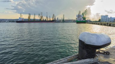Bulgaristan 'ın Varna kentinde deniz limanı ve sanayi vinçleri üzerinde gün batımı