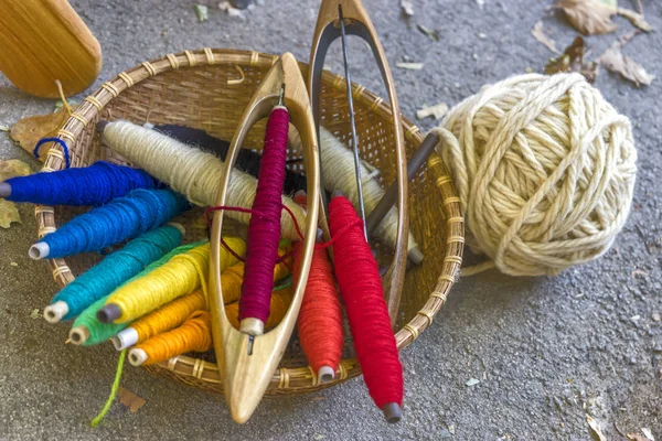 Tools voor een weefgetouw in een mand: katoen garen geverfd in natuurlijke kleuren, Shuttle, bal van draad. Close-up. — Stockfoto