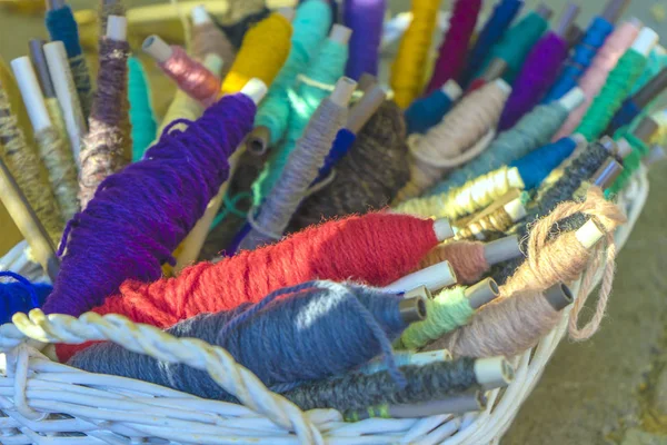 Tools voor een weefgetouw in een mand: katoen garen geverfd in natuurlijke kleuren, Shuttle, bal van draad. Close-up. — Stockfoto