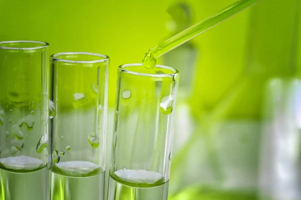 Eppendorf test tüpleri bir raf üzerinde bir damlacık ile Pipet ucu. Yakından kapatın. Yeşil tonlama.