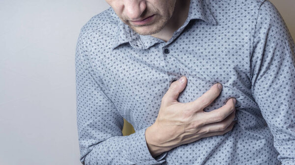 Мужчина, страдающий от острой сердечной боли, боли в груди. Концепция болезни сердца
