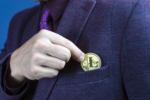 Empresario colocando un Bitcoin en el bolsillo de su chaqueta en una vista cercana de sus dedos y la moneda . —  Fotos de Stock