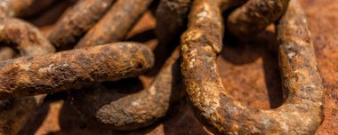 Taş sahilde paslı gemi zinciri. Kapat..