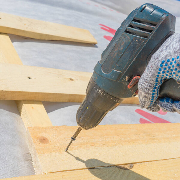 Photo wooden roof construction and screwdriver, symbolic photo for home, house building