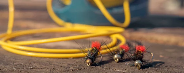 Fly Fishing Reel: İyi kullanılmış bir balık oltası ahşap bir zemin ve sinek yemi üzerine kuruludur.. — Stok fotoğraf