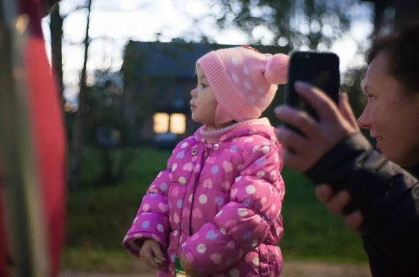 Прогулки девочек с дочерью в вечернем городе и разговор по видеосвязи с отцом . — стоковое фото
