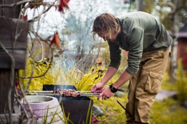 Bir adam Mongal üzerinde Kebap Bahçe onun arsa içinde patates kızartması.