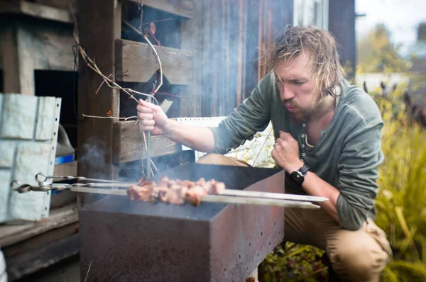 Bir adam Mongal üzerinde Kebap Bahçe onun arsa içinde patates kızartması.