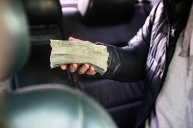 Rus para büyük bir demet elini sıktı.