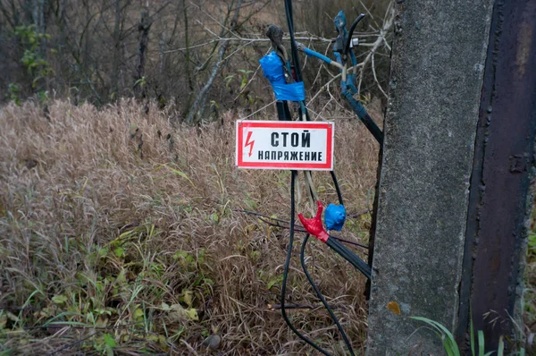 The sign stand voltage hanging on the wires — Stock Photo, Image