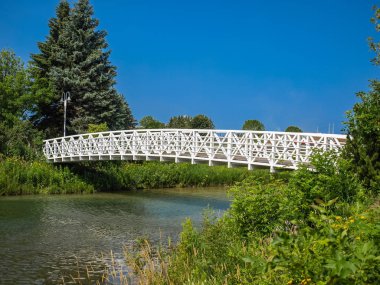 Ontario, Kanada küçük bir nehrin karşısındaki köprü ayak. Bu Saulte St Marie, öğleden sonra güneşin altında parlayan beyaz ayak köprü yeni boyalı yakındır