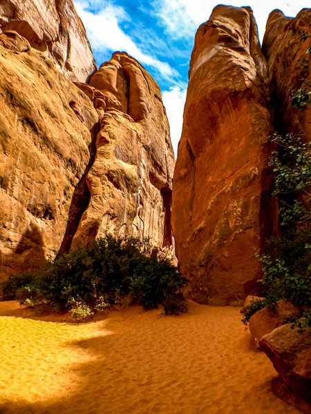 Yerdeki kumla birlikte gökyüzüne yükselen dev kumtaşı kayaları, Arches Ulusal Parkı, UT, ABD