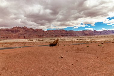 Dev kayanın arkasında görülen dağ sırası - güzel bulutlar, Vermillion uçurum sırası, Page, AZ, ABD